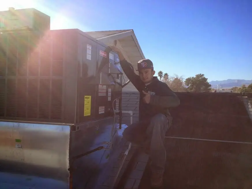 HVAC technician performing Boiler Repair on a rooftop unit in Brownwood